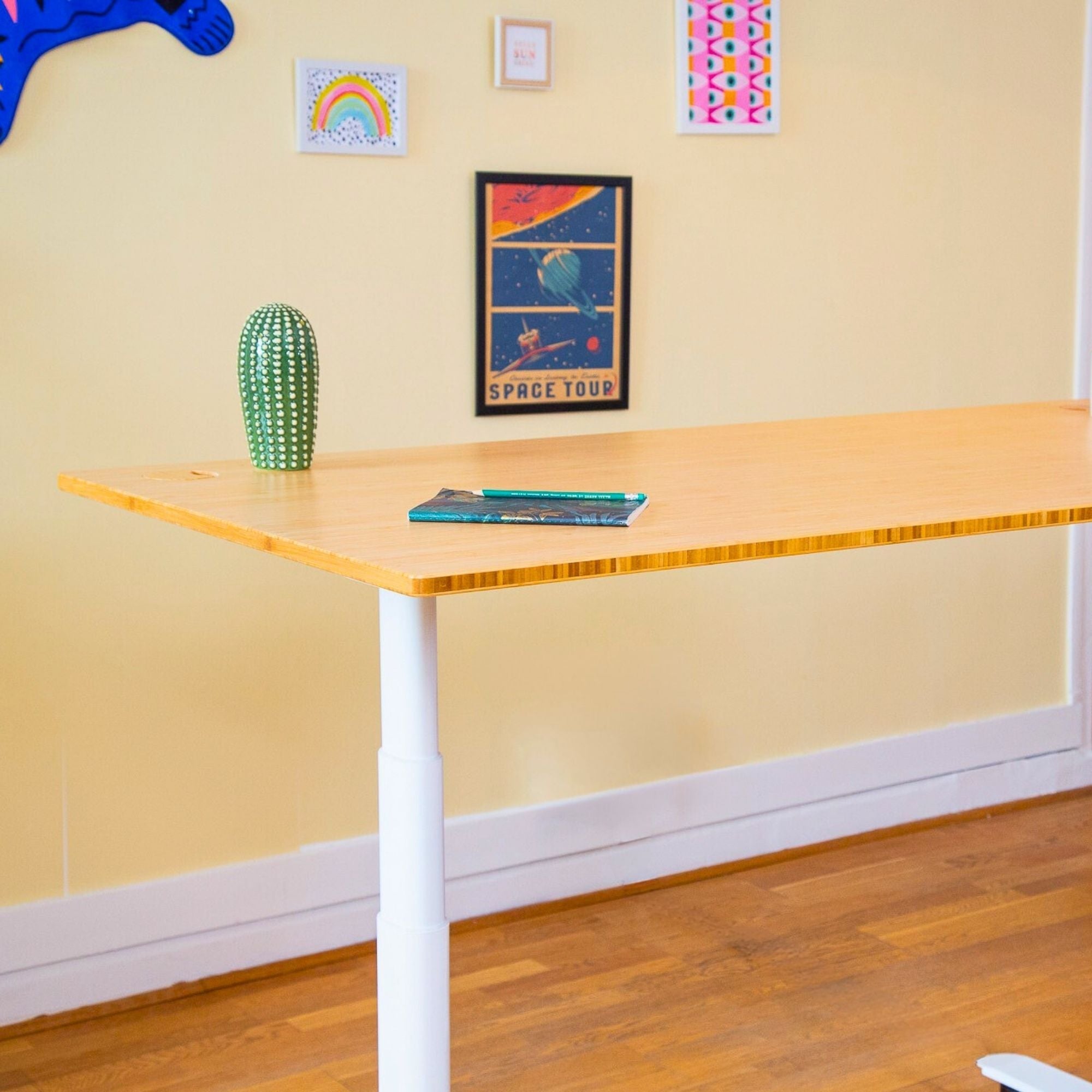 Utilisateur créant une illustration debout sur un bureau assis debout, espace de travail créatif avec plateau bois et rangement intégré