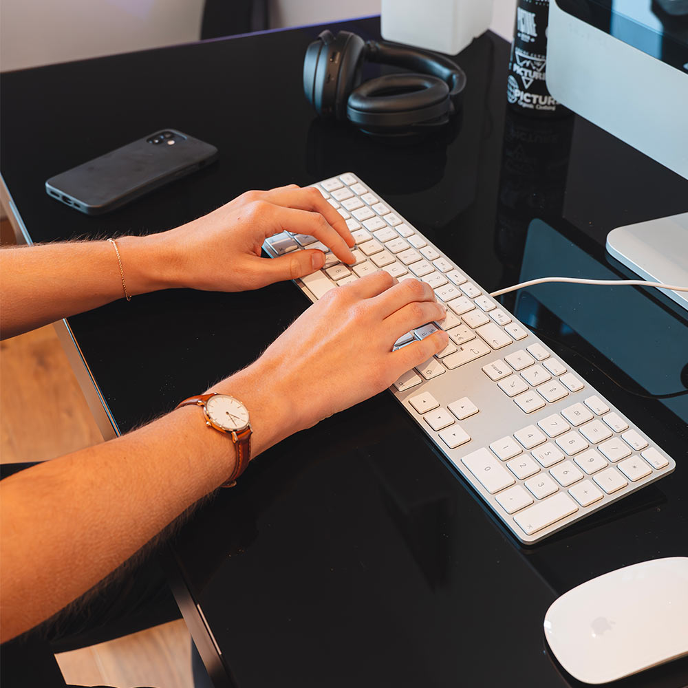 Bureau assis-debout électrique CONNECT noir en position haute dans un intérieur moderne.