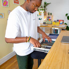 Bureau assis-debout Dynamic Connect avec plateau en bambou naturel, vue latérale sur le piétement blanc.