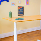 Utilisateur créant une illustration debout sur un bureau assis debout, espace de travail créatif avec plateau bois et rangement intégré