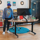 Personne utilisant un bureau assis debout ergonomique dans un espace de travail moderne